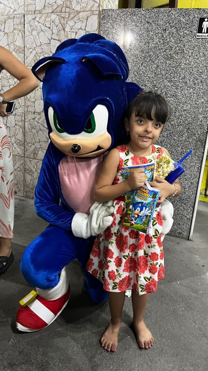 Criança com pipoca ao lado do personagem vivo da Deby On
